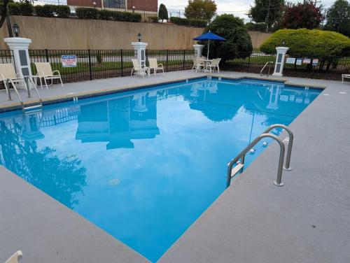 a large swimming pool with blue water and a rail at Best Western Greensboro Coliseum Inn in Greensboro
