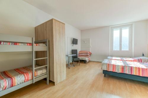 a bedroom with two bunk beds and a desk at Logis Belledonne in Arvillard