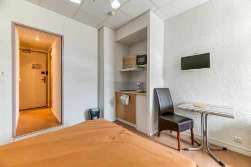 a bedroom with a bed and a desk and a chair at Logis Belledonne in Arvillard