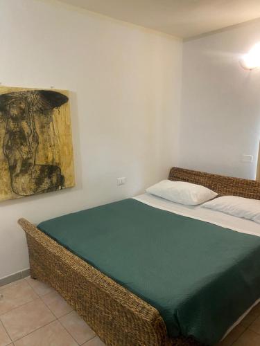 a bed in a room with a painting on the wall at Ca' Rossa in Roe