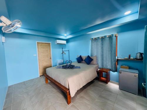 a bedroom with a bed in a blue room at Baan Suan Sunset in Ban Laem Sai