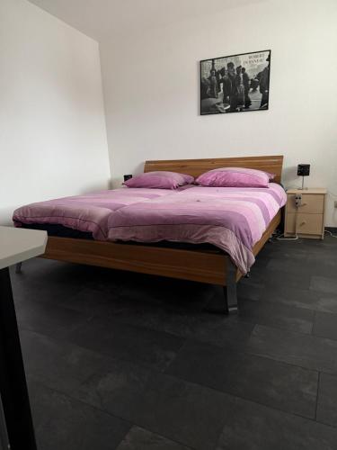 a bedroom with a bed with a purple blanket at Barrierefreie Ferienwohnung in Erkelenz