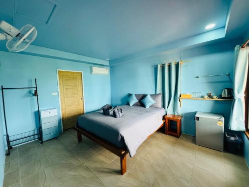 a blue bedroom with a bed in a room at Baan Suan Sunset in Ban Laem Sai