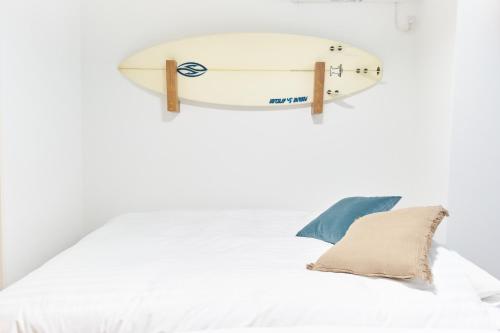 a surfboard hanging on a wall above a bed at Z LAND Enoshima in Fujisawa