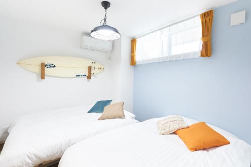 a bedroom with a bed and a surfboard on the wall at Z LAND Enoshima in Fujisawa