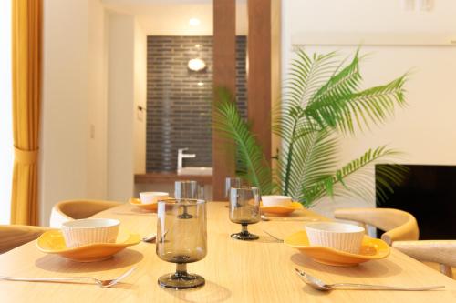 a wooden table with glasses and dishes on it at Z LAND Enoshima in Fujisawa