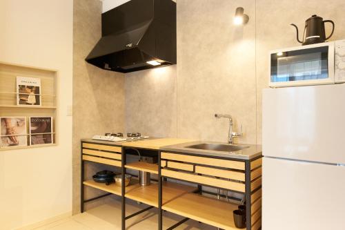 a kitchen with a sink and a refrigerator at Z LAND Enoshima in Fujisawa