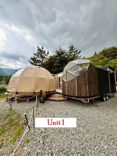 a couple of tents and a trailer on gravel at Fuji Dome Glamping in Fujikawaguchiko