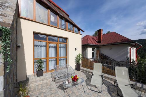 a balcony of a house with a table and chairs at Mont'Arte - Private Art retreat Villa in Buşteni