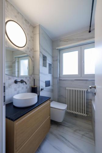 Un baño con lavabo, inodoro y espejo. en Luxe Davos Residence with Views Private Balcony, en Davos