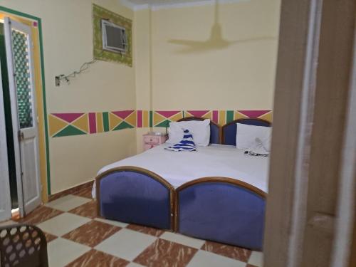 a bedroom with a blue bed in a room at Princess Square Hotel in Luxor