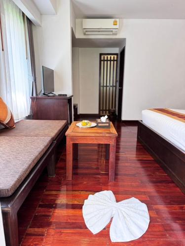a hotel room with a bed and a table at Samui Paradise Chaweng Beach Resort in Chaweng