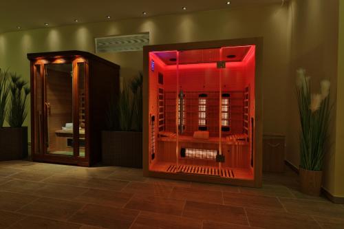 a hot tub with red lighting in a room with plants at CAREA Residenz Hotel Harzhöhe in Hahnenklee-Bockswiese