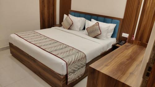 une chambre avec un grand lit avec une tête de lit en bois dans l'établissement Chocolate Inn, Patna, à Patna