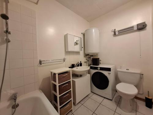 a bathroom with a toilet and a sink and a tub at Namasté 'Au vieux Poitiers' 1 rue Pierre Semard 86530 in Naintré