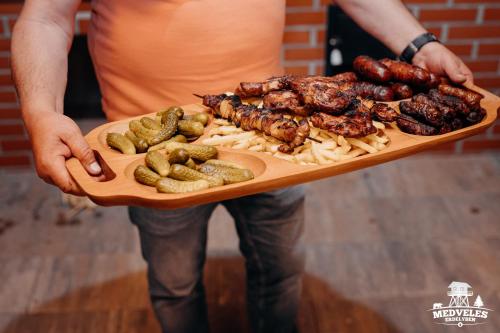 a person holding a plate of food on a board at Transylvania Apartments in Borzont