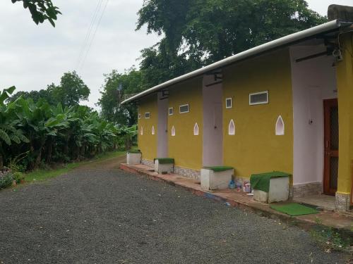 a yellow building with a row of windows on it at Tarangini Farmstay in Maheshwar