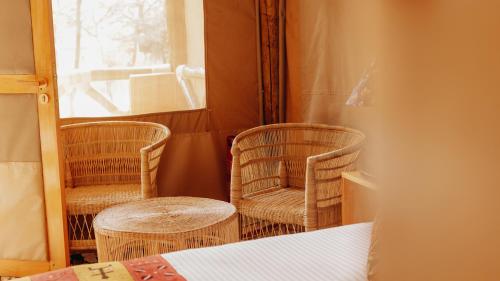 a room with two chairs and a table and a window at Kipekee Zuri Camp in Ololaimutiek