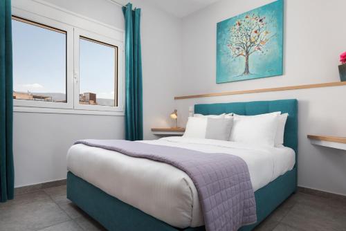 a bedroom with a large bed and two windows at Acropolis Sandra Homes in Athens