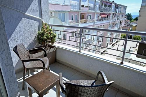 a balcony with two chairs and a table and chairs at Lihnidos Home, Central Apartment, AC, Lake Access, Beach in Ohrid