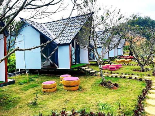 a row of houses with stools in a yard at Homstay Mimosa Mộc Châu in Mộc Châu