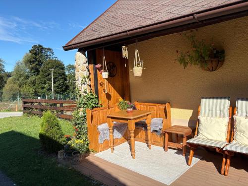 a patio with a table and chairs on a deck at Chalupa za řekou in Vacov