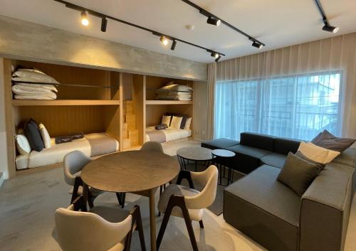 a living room with a couch and a table at Sakura Cross Inn & Sauna Ishigaki in Ishigaki Island