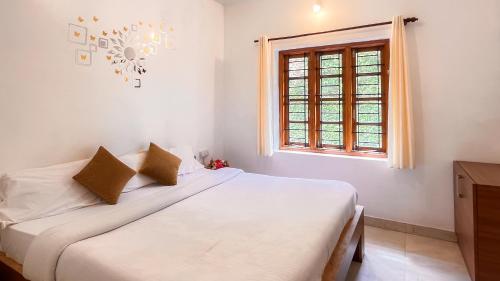 a bedroom with two beds and a window at Willostays Cluster Clouds in Ooty