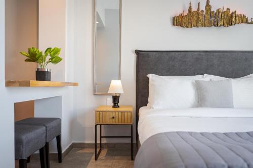 a bedroom with a bed and a table with a lamp at Acropolis Sandra Homes in Athens
