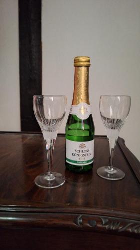 a bottle of champagne and two wine glasses on a table at Bad Wimpfen Altstadt - ruhige, private Unterkunft in Bad Wimpfen