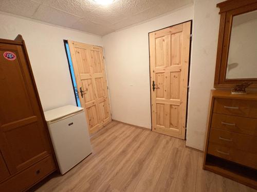 an empty room with two doors and wooden floors at Chalupa za řekou in Vacov