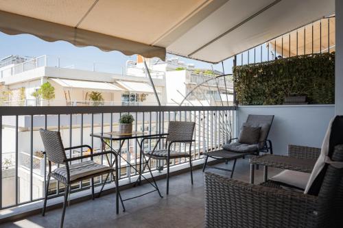 a patio with chairs and a table on a balcony at Acropolis Sandra Homes in Athens