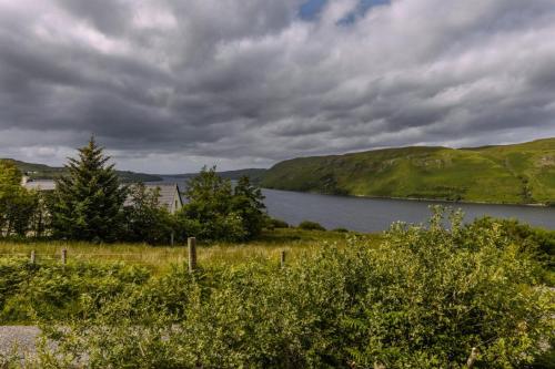 a view of a body of water with trees and hills at Luxury Seaview Cottage by Fairy Pools 3 in Carbost