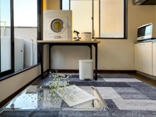 a room with a glass table and a microwave at MANDO Hotel 101 in Tokyo