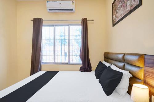 a bedroom with a large bed and a window at Hotel O Barkura Bus Terminal Formerly Navanil in Nalbāri