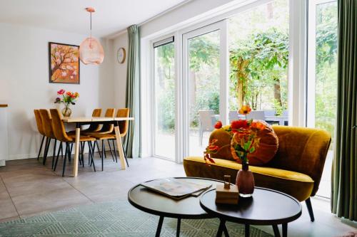 a living room with a yellow couch and a table at Vakantiehuis Vliegend Hert Veluwe in Nunspeet