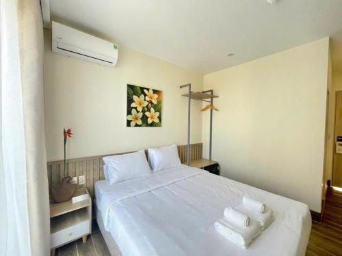 a bedroom with a large white bed with two pillows at Cham Charm Home Mui Ne in Mui Ne