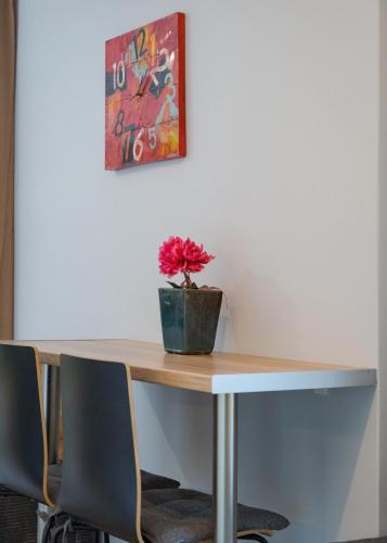 a table with a vase with a flower on it at Acropolis Sandra Homes in Athens