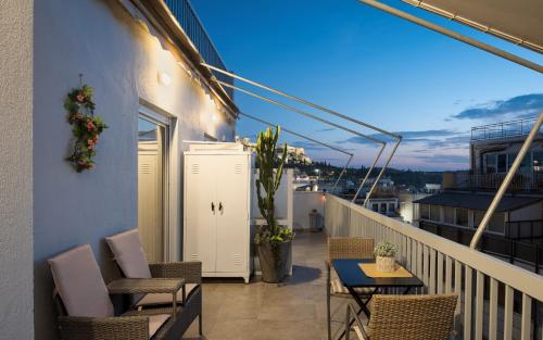 a balcony with chairs and a table on a building at Acropolis Sandra Homes in Athens
