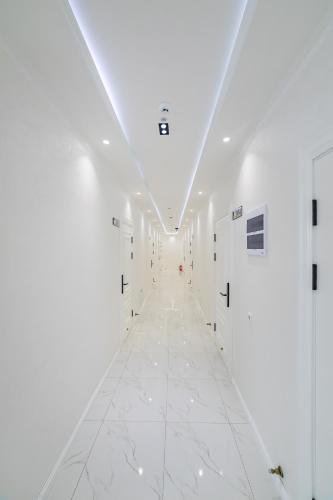a hallway with white walls and white marble floors at Potter Hotel Khiva in Khiva