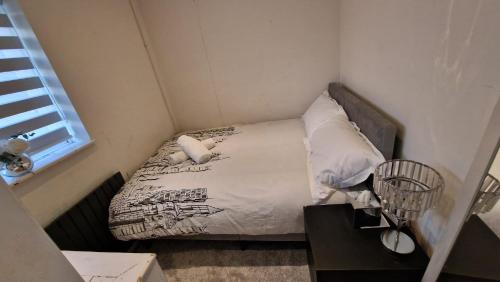 a small bed in a small room with a window at The Dorking Hideaway in Dorking