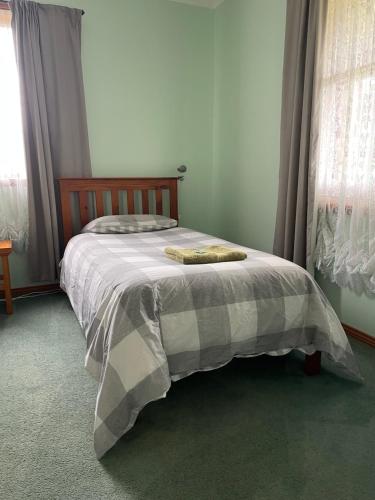 a bed with a blanket on it in a bedroom at Our Cottage in Ross