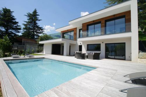 CatonにあるVilla d'exception Piscine vue et accès lac directの家の前にプールがある家