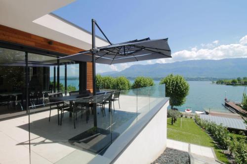 CatonにあるVilla d'exception Piscine vue et accès lac directの水の見えるガラス張りの家