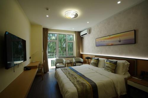 a hotel room with a bed and a television at Beidaihe Yijing Hotel in Qinhuangdao