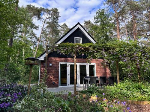 a small house in the middle of a garden at Vakantiehuis Vliegend Hert Veluwe in Nunspeet