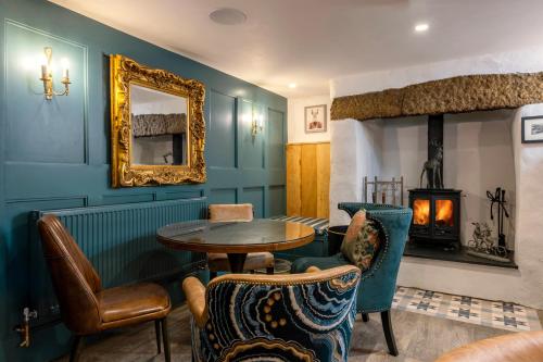 una stanza con tavolo, sedie e camino di Basset Arms, Portreath, Cornwall a Portreath