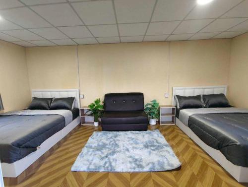 a room with two beds and a chair in it at Bansuanariya in Ban Na Yang
