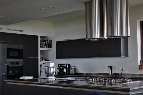 a kitchen with black cabinets and a stove top oven at Sea & Serenity in Agii Dimitrios ke Panteleimon