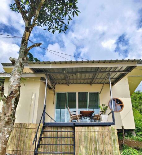 a house with a porch with a table and chairs at Bansuanariya in Ban Na Yang